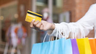Mulher com Cartão de Crédito e Sacolas de Compras